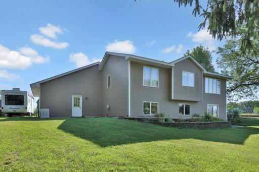 Rear of the home with Whole House Generator to the left end of the house or to the right of the travel trailer.