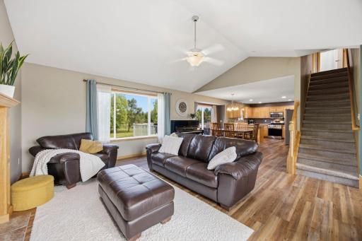 The main floor space is perfect for gatherings with friends and family flowing seamlessly into the dining and kitchen areas. to the right is access to the upper level.