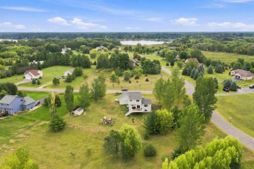 This aerial photo pictures the back of the home, deck, and shed. The land is perfect to enjoy many hobbies and interests!