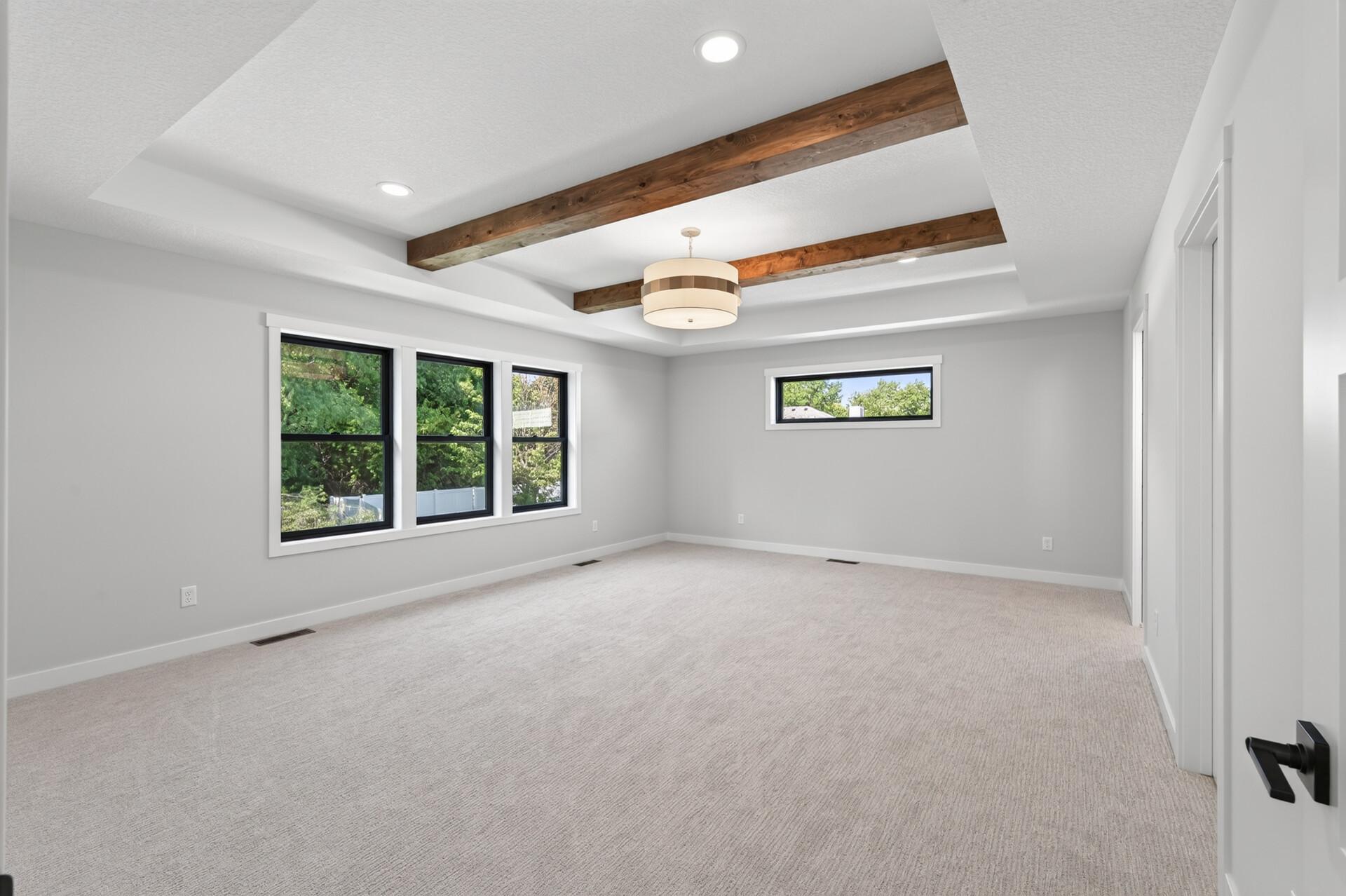 Primary bedroom is oversized with wood beams, a full primary ensuite and a massive walk-in closet!