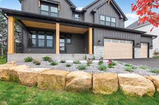 Front exterior with lovely cedar ceiling over the front porch, stone facade, dark exterior and a lovely curb appeal!
