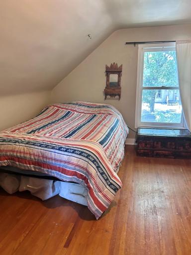 The upper half story of the home has a nice size bedroom. And more hardwood flooring!