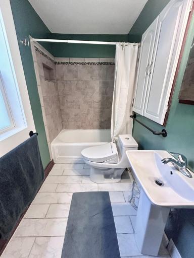 Main floor full primary bedroom ensuite. Right off the bedroom area! Bath tub/shower combo. Pedestal sink, tile flooring, toilet with bidet!