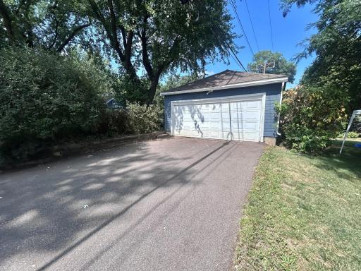 View of double garage from street. Driveway is asphalt.