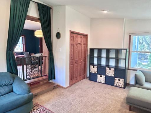 View in the family room showing the closet and two steps up into the dining area and kitchen.