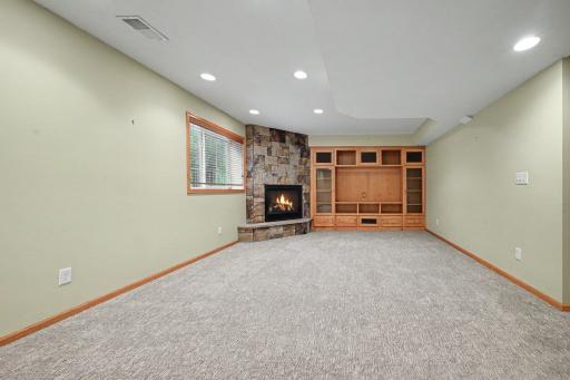 Extra large rec room in the lower level. Notice the stone fireplace and and the customer built-ins