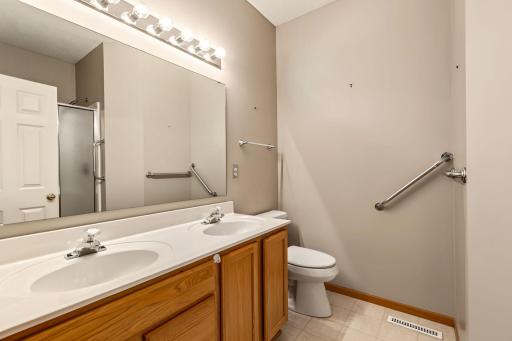 Primary bath with double sinks, shower and grab bars for safety.