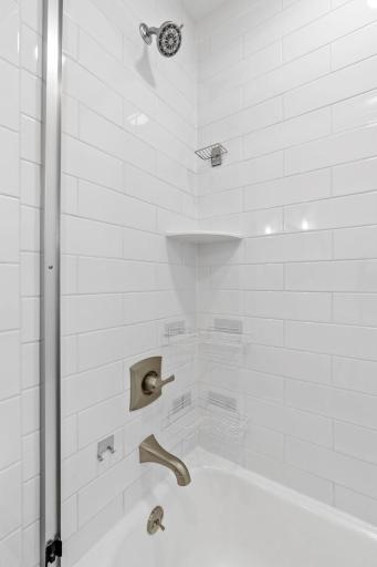 Full bath surround with subway tile and glass shower door.