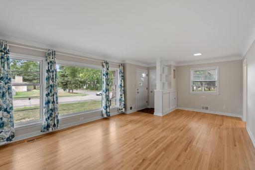 Main floor living room is nearly a wall of windows over looking the front yard with mature trees.