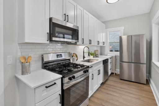 Kitchen with new SS appliances, cabinets, countertops and tile backsplash