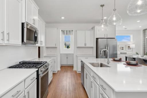Photo for 762 151st Lane NW, Andover, MN 55304 - listing #7132471 Bright, beautifully finished kitchen with crisp white cabinetry, quartz countertops, stainless steel appliances, and abundant storage. The oversized center island provides generous prep space and casual seating.
