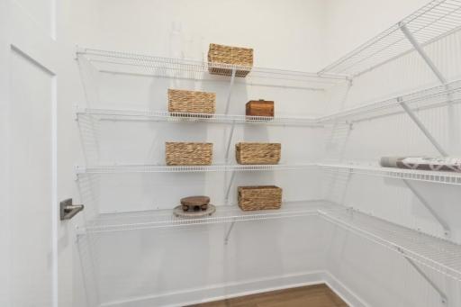 Spacious walk-in pantry provides excellent storage and organization, keeping kitchen essentials conveniently tucked away.