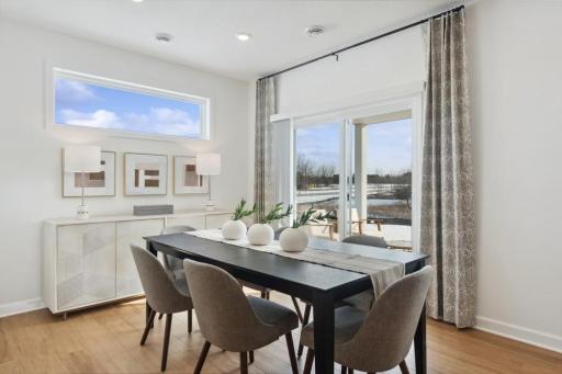 Sun-filled dining area with large windows and sliding doors to the covered patio, creating an effortless connection between indoor and outdoor living.
