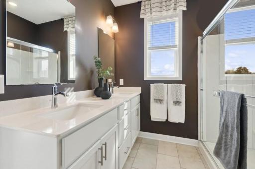 Beautiful private owner’s bath features a dual-sink vanity, abundant storage, and a spacious walk-in shower for a comfortable, spa-like start to the day.