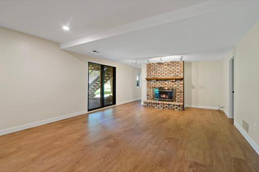 Head down to the walk out lower level with wood burning fireplace and floor to ceiling brick surround.