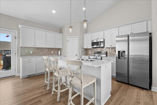 Open-concept kitchen featuring a large center island, pendant lighting and easy flow into the dining and living areas.