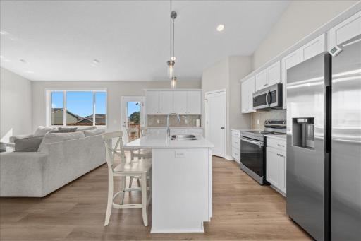 Bright, open living room and kitchen with vaulted ceiling, large windows and walk out to deck.
