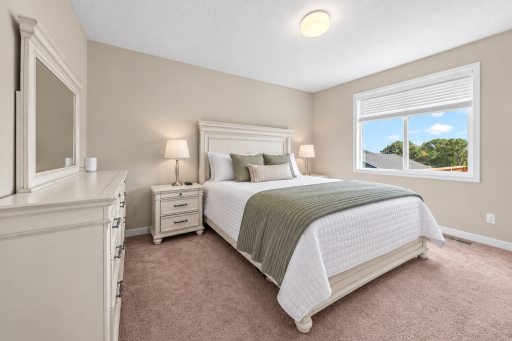 Spacious bedroom with neutral finishes, soft carpeting and ample room for furnishings.