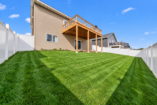 Spacious fenced backyard with elevated deck, sprinkler and plenty of green space. virtually enhanced