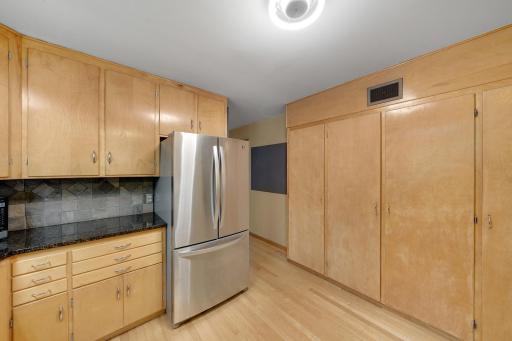 Full wall of cabinets and the hallway leading to main floor laundry.