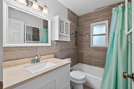 The main floor full bath has custom tile throughout.