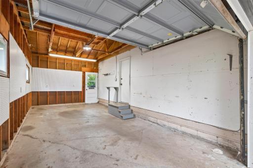Garage has high ceilings and storage above. Long enough to have a work bench too.