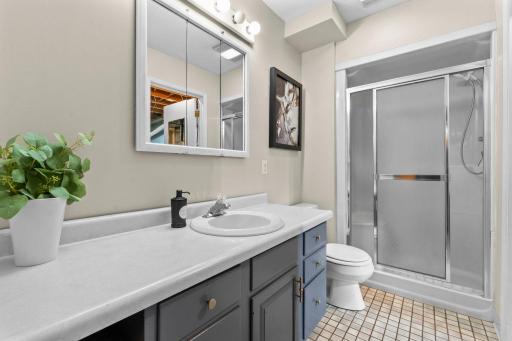 Both lower-level bedrooms are conveniently situated near a shared Â¾ bathroom featuring a walk-in shower, single vanity, and tile flooring.