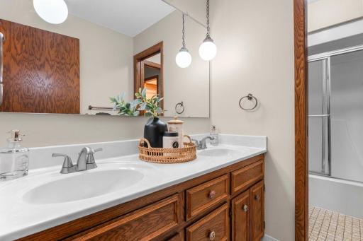 The walk-through full bathroom features dual vanities and a tub/shower combination.