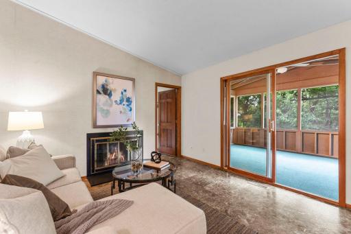 The family room is highlighted by a wood-burning fireplace and access to the spacious three-season porch.