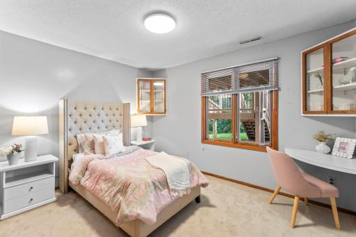 The lower level offers two additional bedrooms. This one features carpeting, dual closets, a rear-facing window, and built-in shelving for books or dÃ©cor.