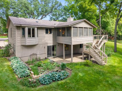 The property features an oversized concrete driveway with a basketball hoop, while the peaceful, tree-lined backyard provides a private setting where wildlife is often spotted.