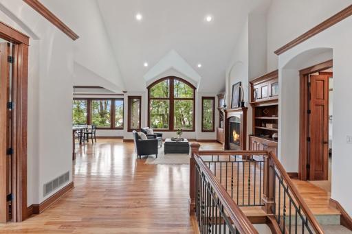 The stunning vaulted great room features a dramatic wall of windows overlooking the beautifully landscaped backyard.