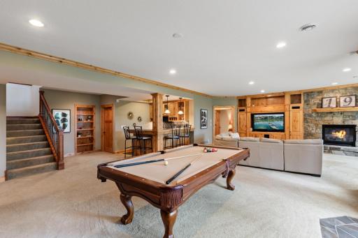 The lower level is a true entertainment destination, complete with a spacious recreation room, cozy family room with fireplace, billiards area & wet bar area