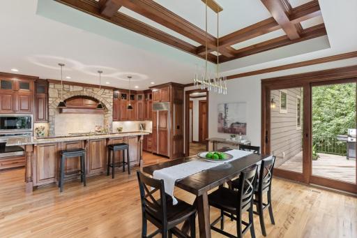 The gourmet custom kitchen showcases stone accents, custom cabinetry, a spacious center island, and seamless connection to the elegant dining and comfortable living areas.