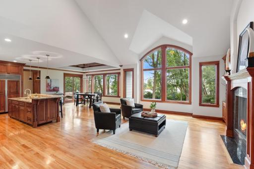 The stunning vaulted great room features a dramatic wall of windows overlooking the beautifully landscaped backyard.