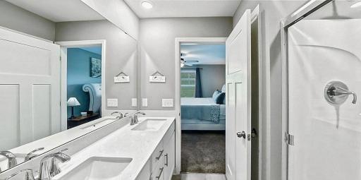Private primary bathroom with quartz countertop and modern finishes.