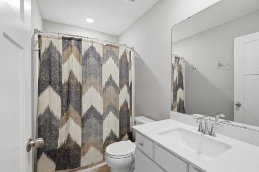 Full upper-level bathroom with quartz countertops and plenty of storage.