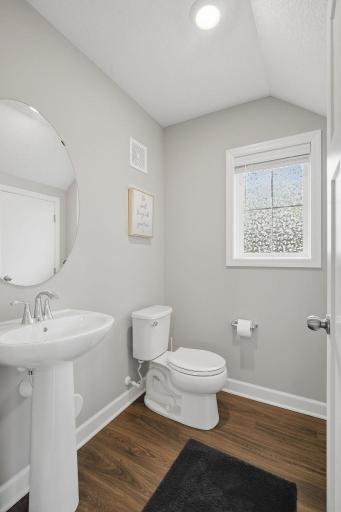 Main-level half bath with quartz countertop and modern finishes.