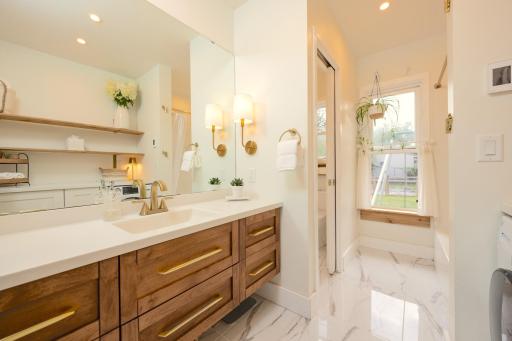 High end touches throughout the bathroom, including stunning tile flooring and a water closet