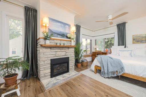 The spacious primary bedroom features a stone gas fireplace
