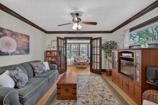 The living room offers a comfortable gathering space with access to the bright enclosed porch.