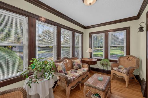 A sun-filled enclosed front porch offers a welcoming spot to relax and enjoy the neighborhood views.