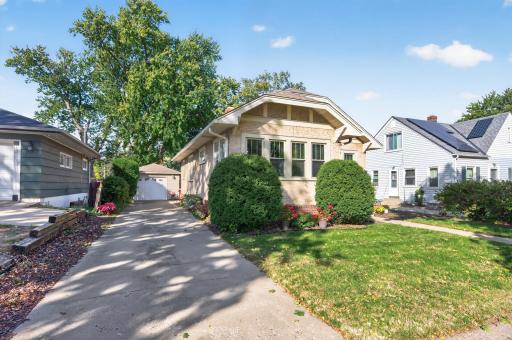 The concrete driveway extends alongside the home toward the detached garage.