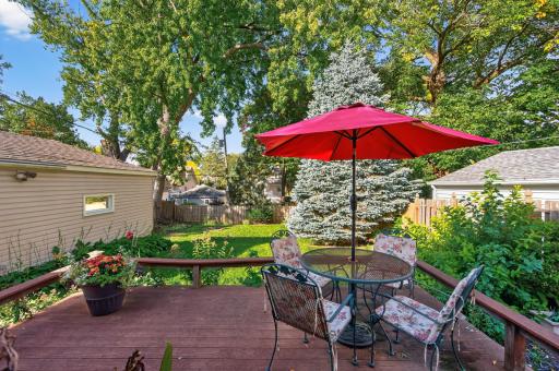 The deck provides an inviting place to dine or unwind beneath the backyardâs mature trees.