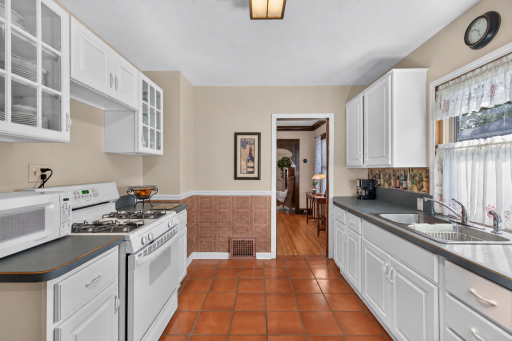 The kitchen provides ample cabinet storage and convenient access to the adjoining dining room.