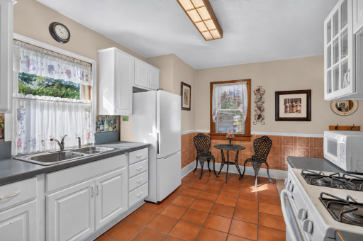 A refrigerator replaced in 2025 complements the kitchenâs white cabinetry and cozy dining nook.