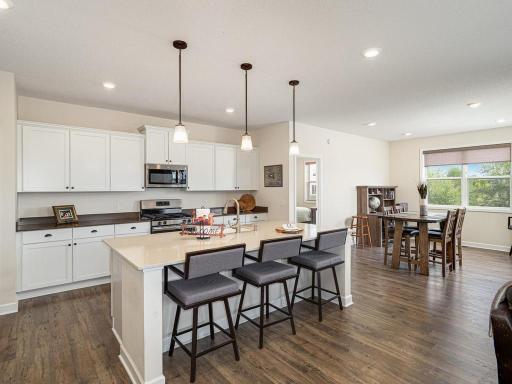 Large center island/breakfast bar and quartz counters! Stainless appliances include gas range. LTV premium vinyl plank flooring. Plenty of cabinet space and open layout to dining room.