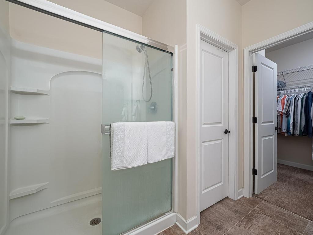 Owners Suite private bathroom features walk-in shower and walk-in closet. Toilet is behind the closed door for privacy.
