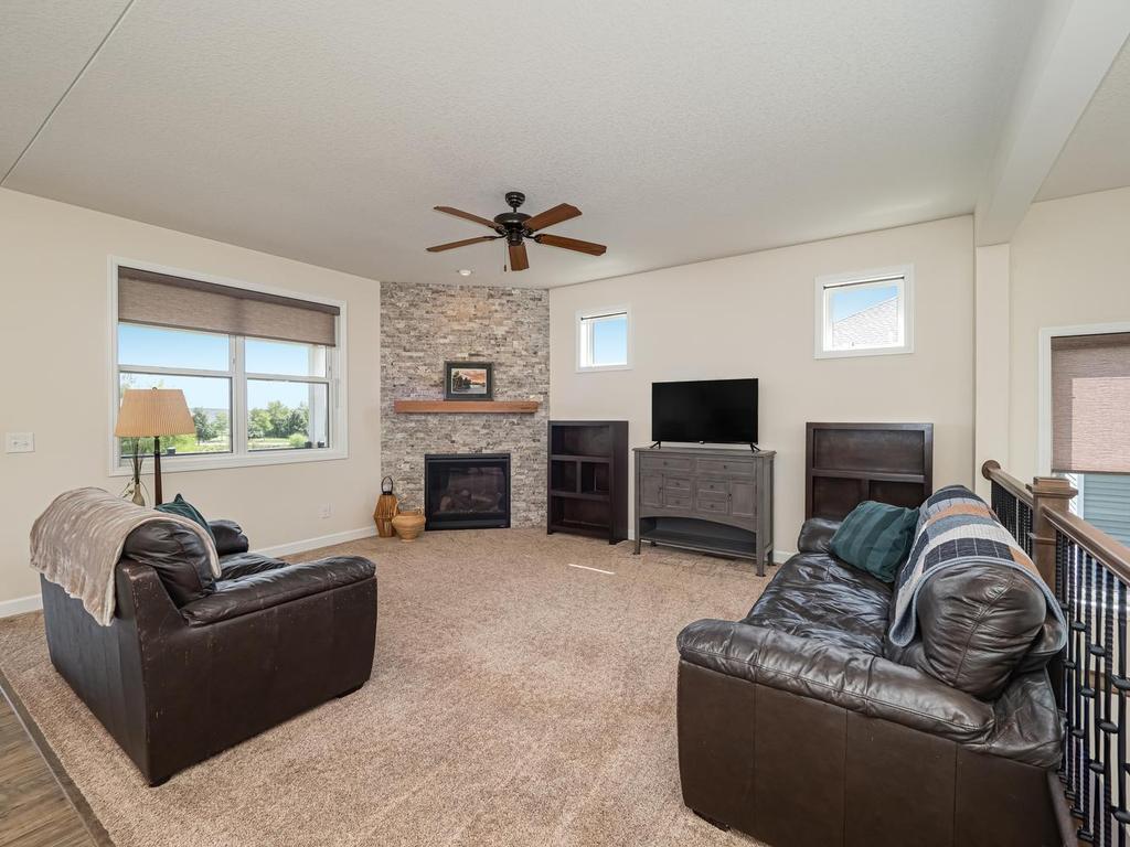Spacious Great Room lets in plenty of natural light. The gas fireplace surrounded natural stone. Double window to left of fireplace overlooks back deck with beautiful views of the pond. Large ceiling fan keeps you cool during hot summer months.