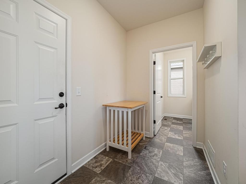 Mudroom entrance to the main floor laundry room. The door to the left goes into attached garage. Makes it easy getting groceries into your kitchen. It has a screen door so you can open the garage door to move cooler air thru the home.